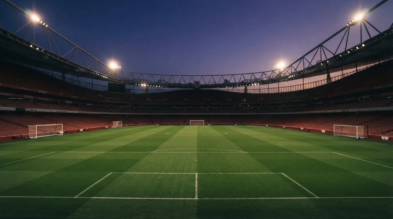 An empty football stadium with floodlight masts at dusk