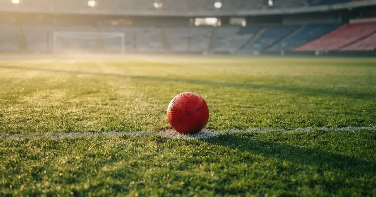A ball on the centre spot of a grass pitch in morning light
