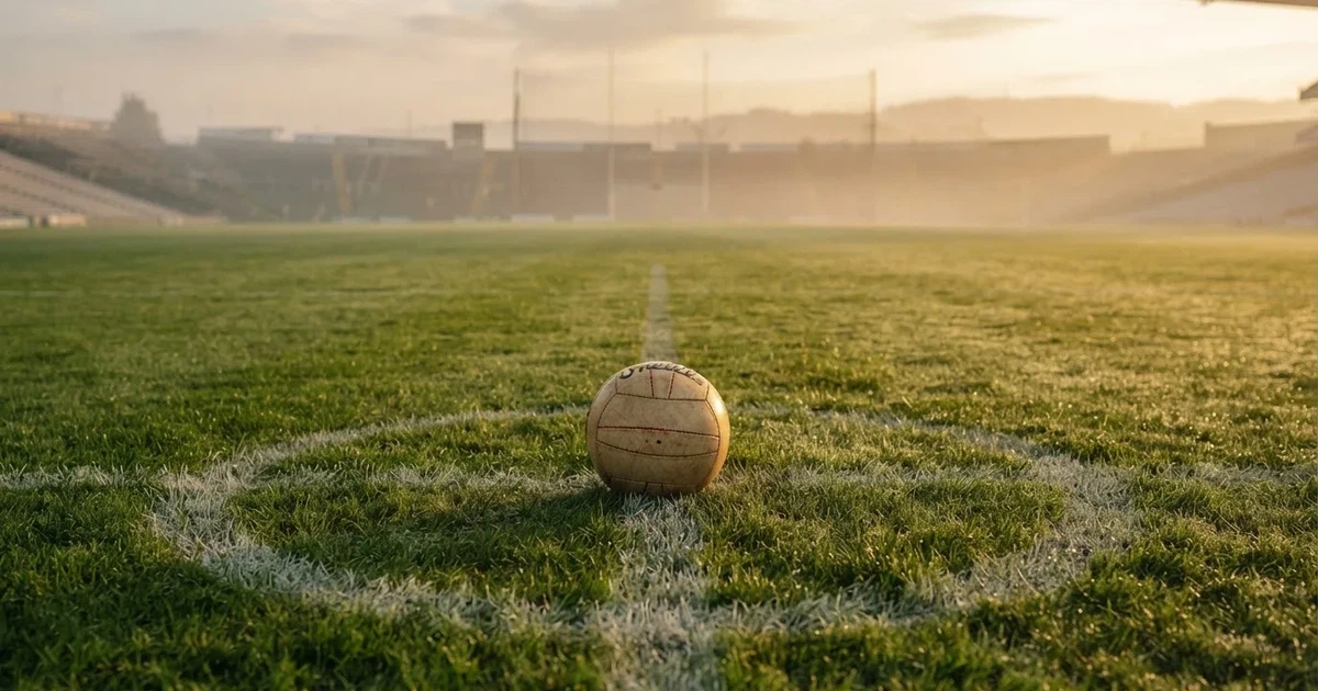 A ball on the centre spot of a grass pitch in morning light