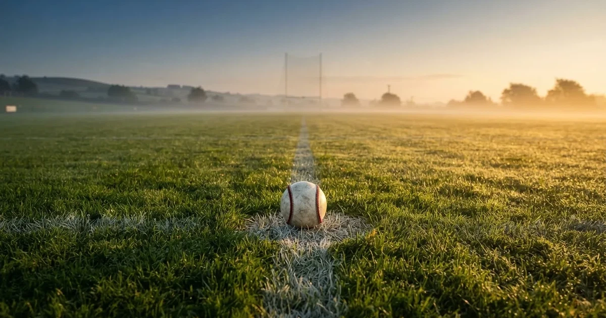 A ball on the centre spot of a grass pitch in morning light