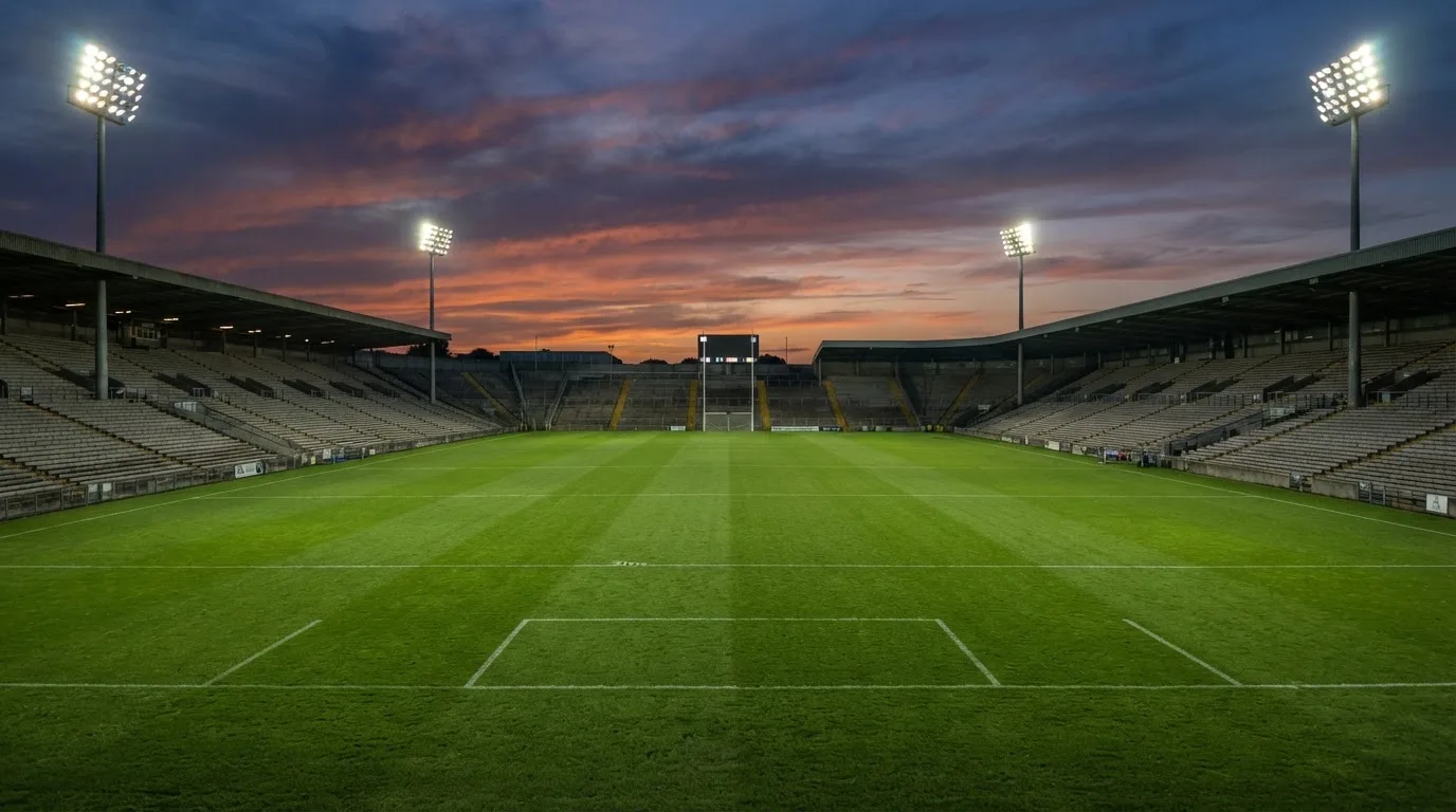 An empty football stadium with floodlight masts at dusk