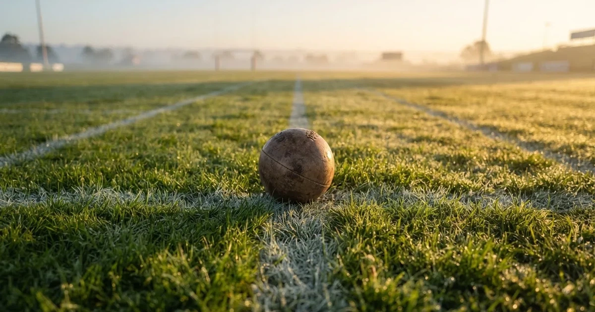 A ball on the centre spot of a grass pitch in morning light