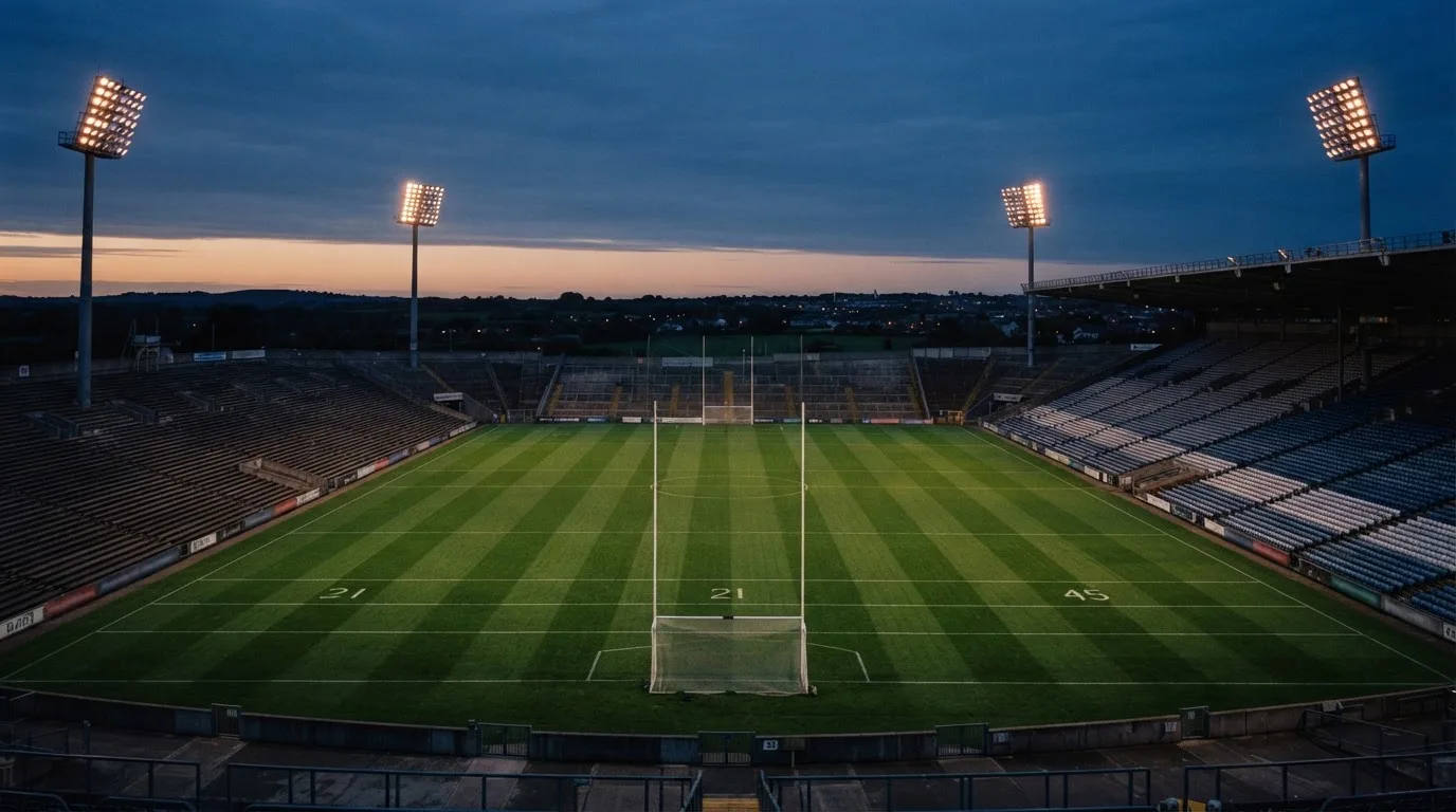 An empty football stadium with floodlight masts at dusk