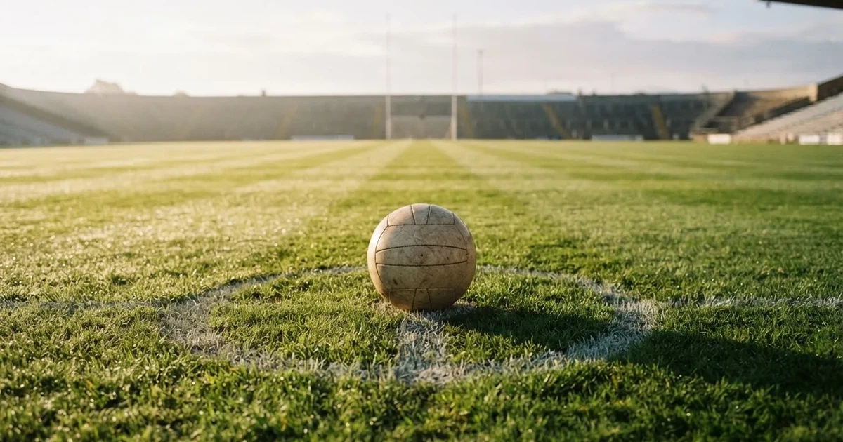A ball on the centre spot of a grass pitch in morning light