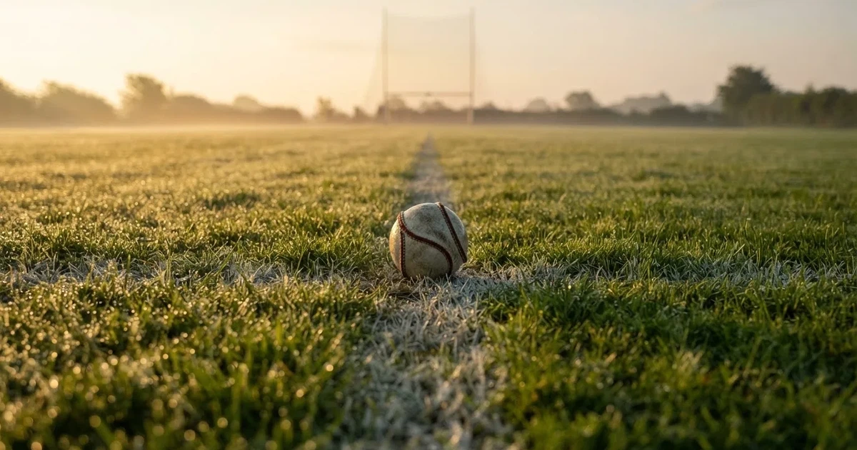 A ball on the centre spot of a grass pitch in morning light